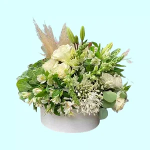 Arreglo floral para condolencias con flores blancas en caja redonda