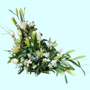 Arreglo floral para pésame con rosas y lilis blancas en diseño diagonal
