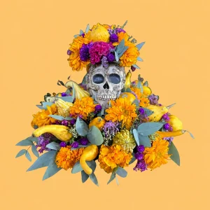 Arreglo Ofrenda con calavera de cerámica decorada, flores amarillas, naranjas y moradas, follajes y calabazas de distintas formas.